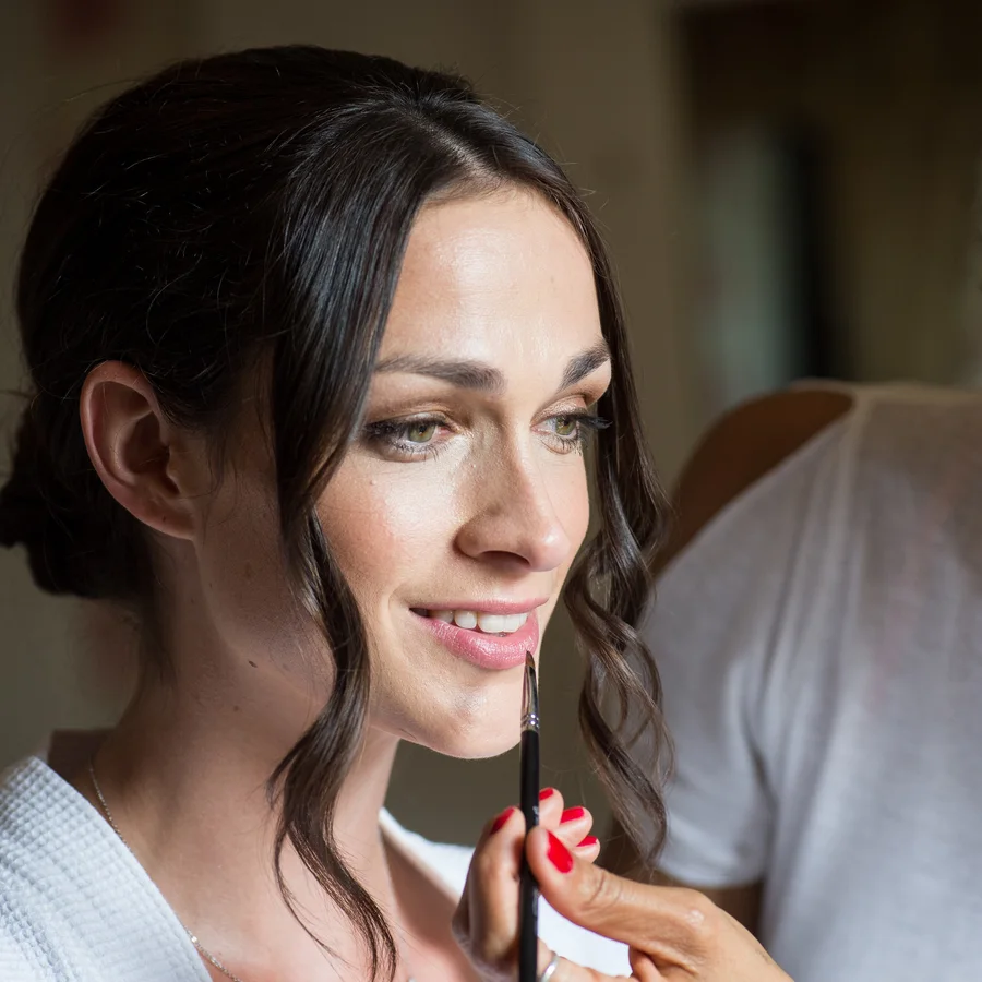 A bride having her make-up applied before her wedding at Langar Hall